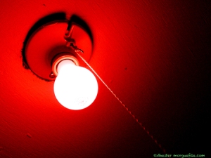 Bright light bulb on red ceiling.